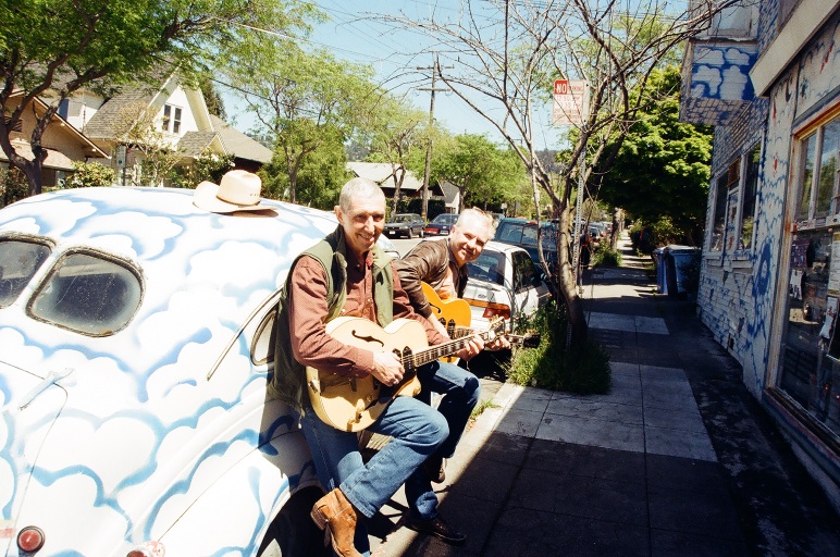 2 white haired old men with guitars